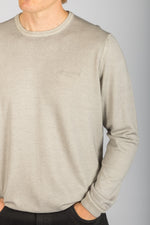 Close-up of embroidered logo on ash beige wool long sleeve jumper