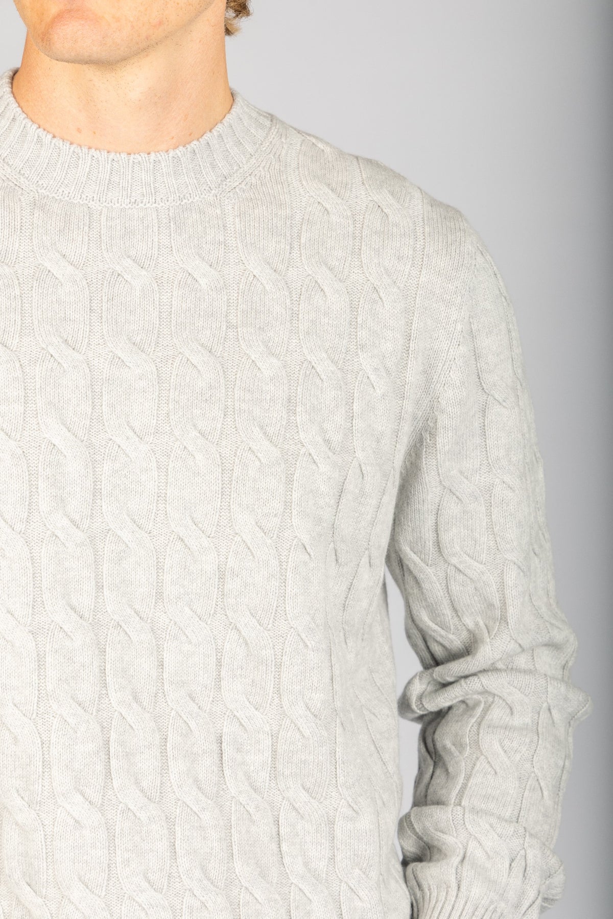 Close-up of cable knit texture on light grey wool-cashmere blend jumper