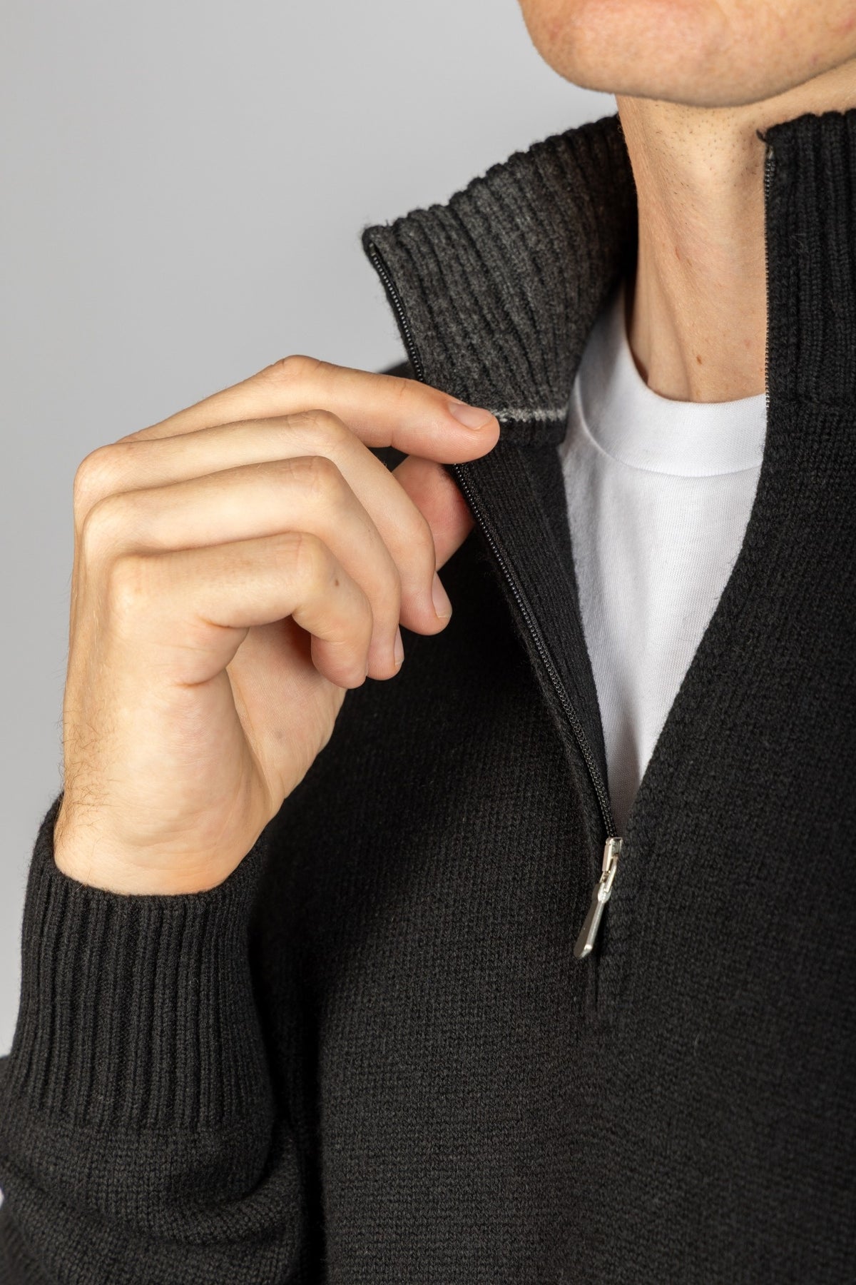 Close-up of funnel neck, metal zip and embroidered sleeve logo