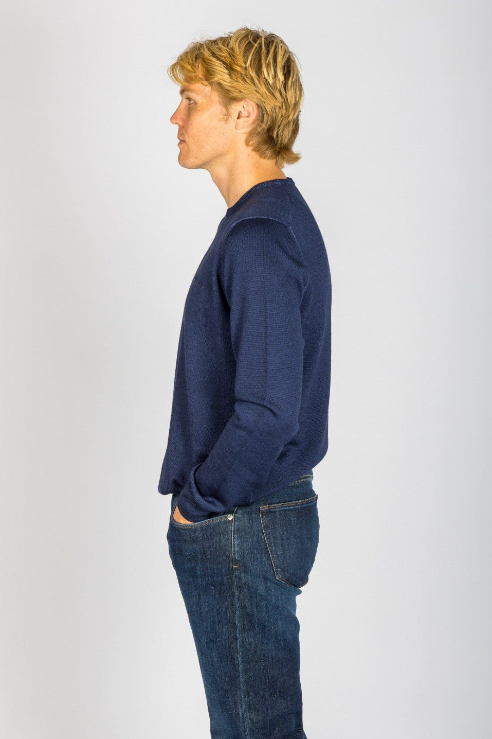 Side profile of navy wool crew neck jumper with embroidered logo